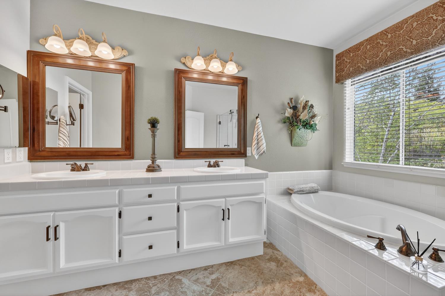 1203 Halidon Way Folsom, CA 95630 - Photo 42 of 98 a bathroom with a granite countertop double vanity sink a mirror and a bathtub