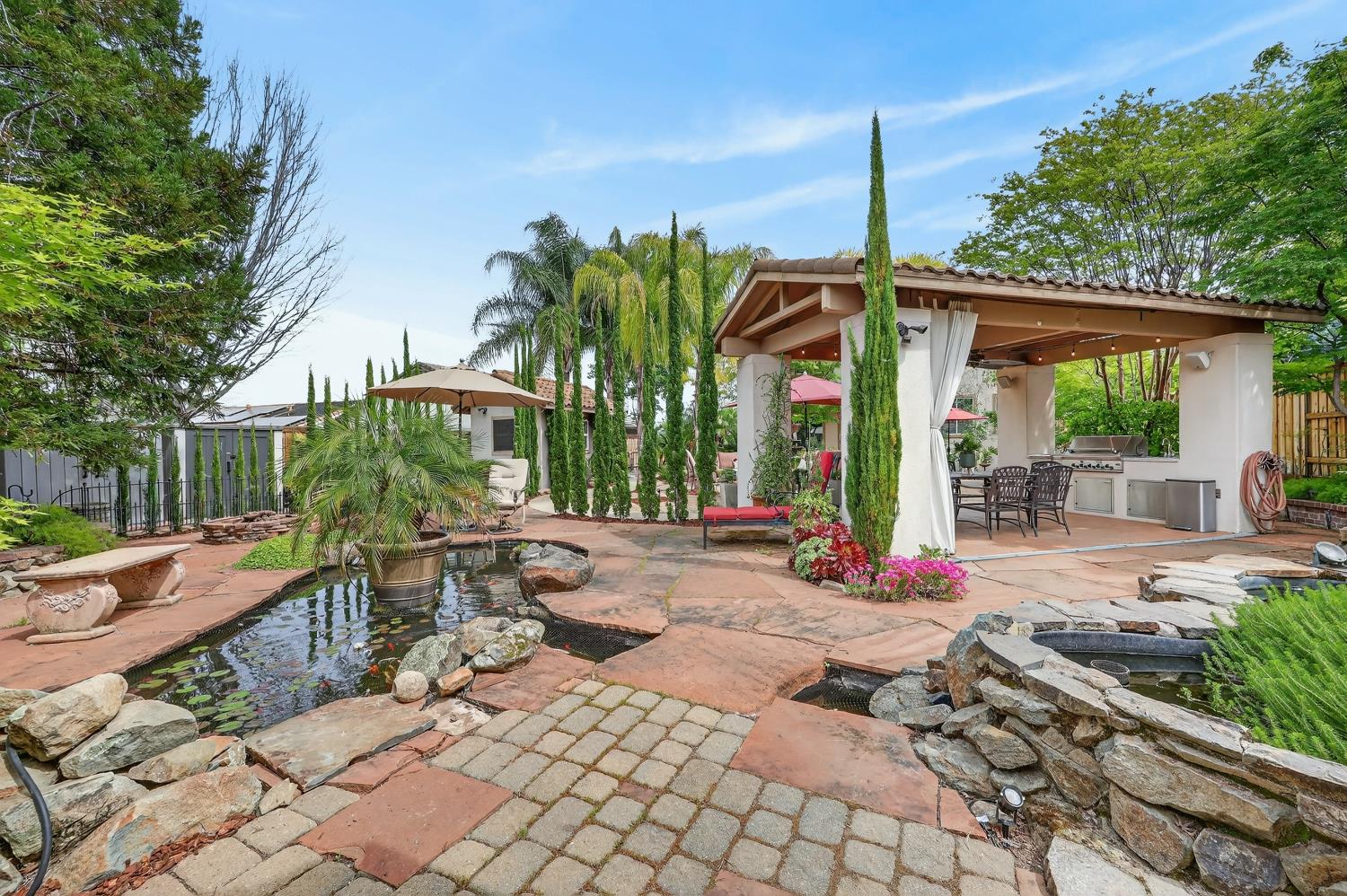 1203 Halidon Way Folsom, CA 95630 - Photo 69 of 98 a view of a patio with table and chairs potted plants and palm tree