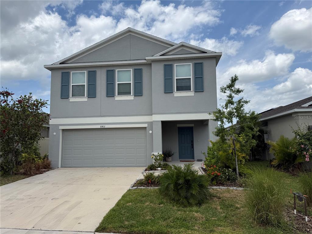 6431 Milestone Loop Palmetto, FL 34221 - Photo 1 of 28 a front view of a house with a yard and garage