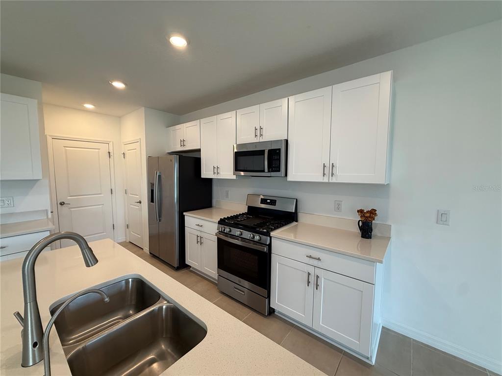 6431 Milestone Loop Palmetto, FL 34221 - Photo 7 of 28 a kitchen with stainless steel appliances granite countertop a stove a sink and a microwave
