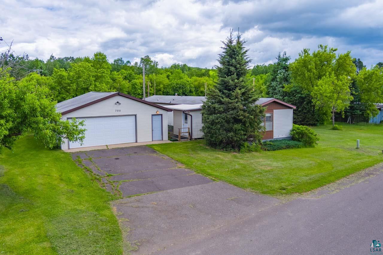 705 4th Street North Biwabik, MN 55708 - Photo 2 of 29 Single-story residence featuring a two-car garage with a white overhead door, an asphalt driveway, and a verdant lawn