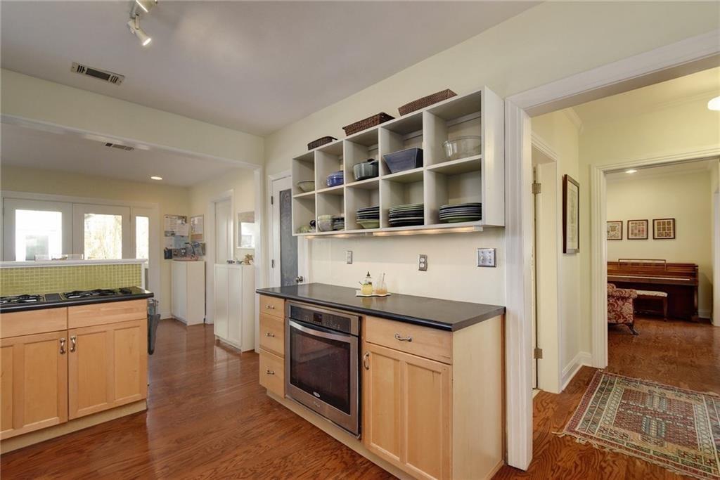 4412 Barrow Avenue, Unit A Austin, TX 78751 - Photo 11 of 28 Kitchen with light brown cabinetry, dark countertops, stainless steel oven, and dark wood-style flooring