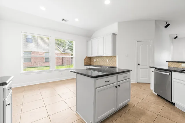 a kitchen with granite countertop a stove sink and cabinets