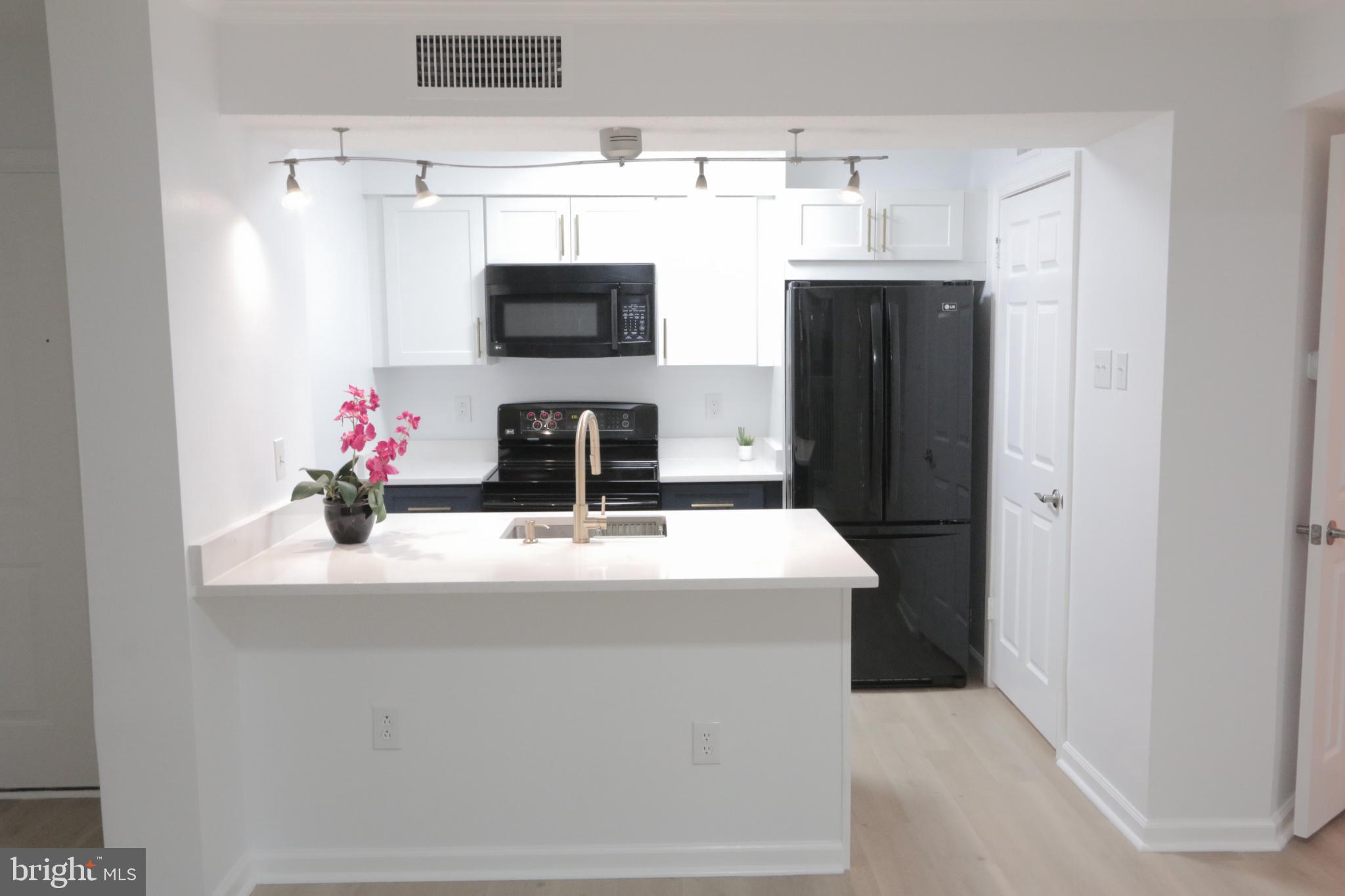 1504 Lincoln Way, Unit 104 McLean, VA 22102 - Photo 11 of 40 a kitchen with stainless steel appliances a microwave and a refrigerator
