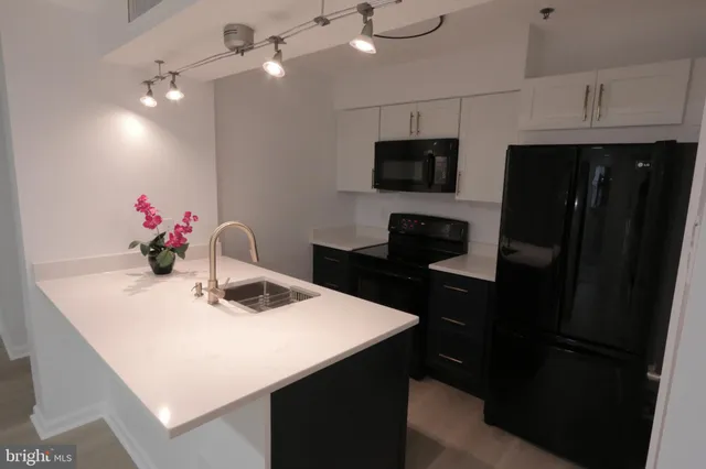 a kitchen with a sink a microwave a refrigerator and cabinets