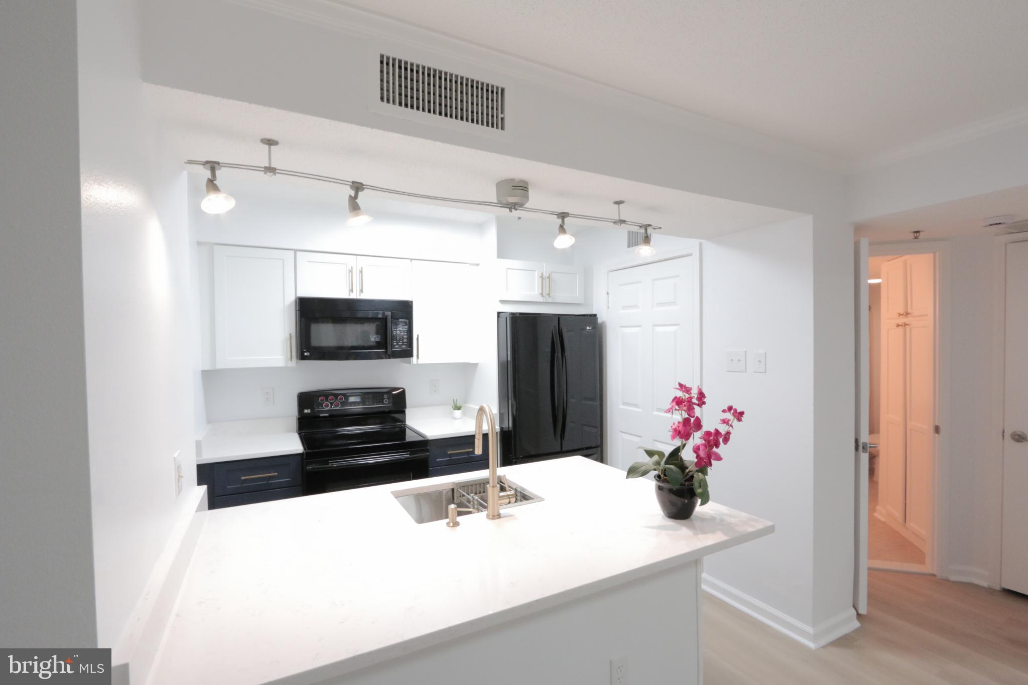 1504 Lincoln Way, Unit 104 McLean, VA 22102 - Photo 15 of 40 a kitchen with a sink refrigerator and microwave