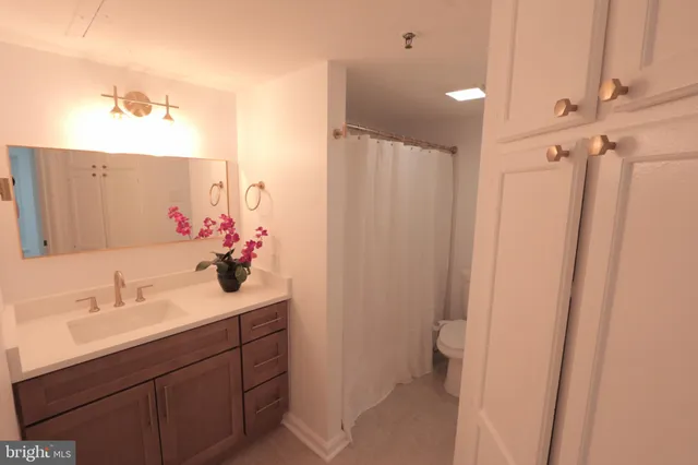 a bathroom with a sink and mirror with toilet