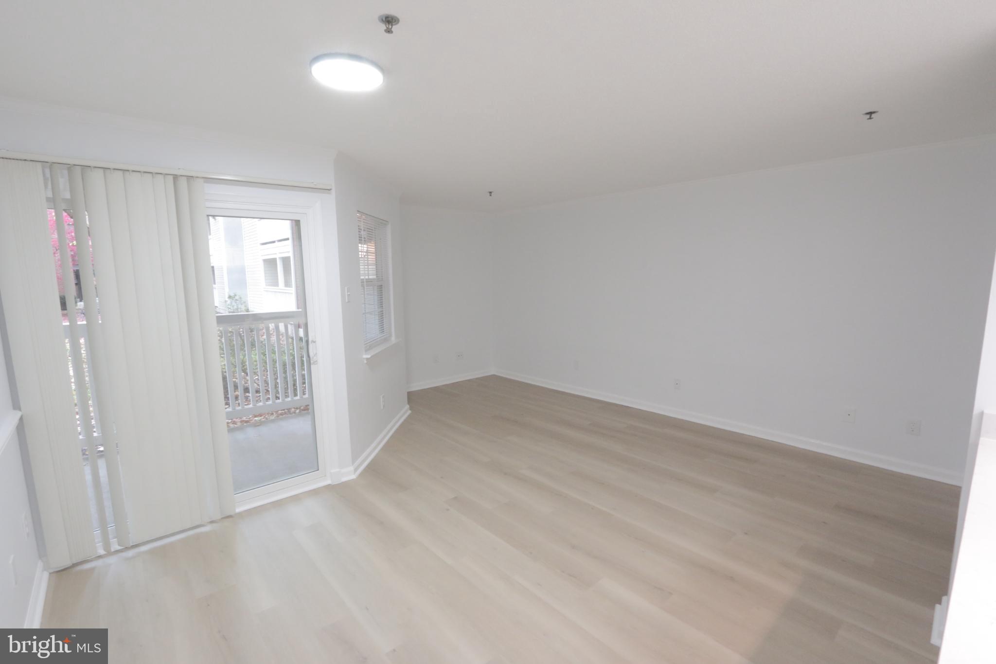 1504 Lincoln Way, Unit 104 McLean, VA 22102 - Photo 3 of 40 a view of an empty room with wooden floor and a window