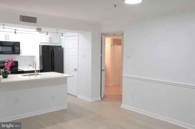 a view of a kitchen with cabinets and refrigerator