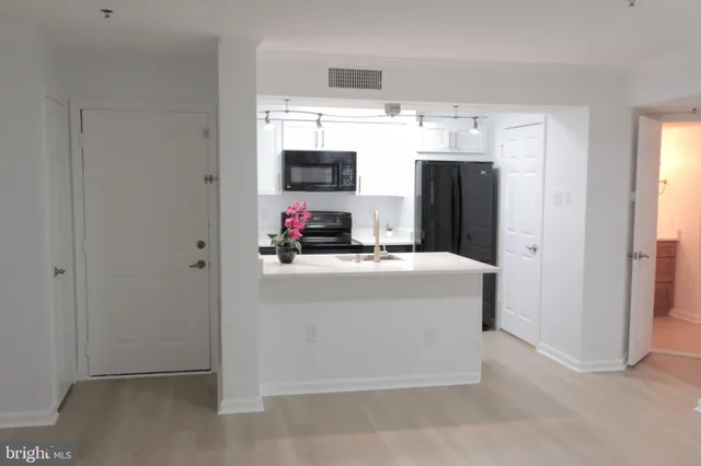 a kitchen with refrigerator and microwave