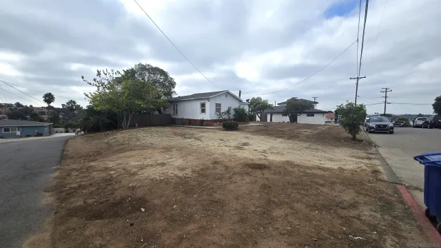 a view of a dirt road and a building in the background