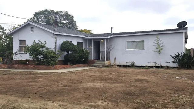a house that has a lot of windows and plants in front of it