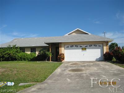 515 Southwest 29th Street Cape Coral, FL 33914 - Photo 1 of 3 a front view of a house with a yard and garage