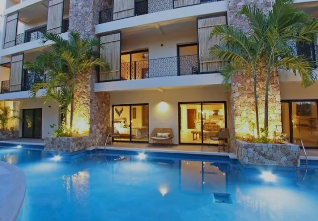 a view of a building with brick walls plants and large tree