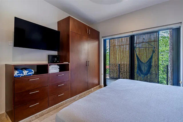 a bedroom with a bed and a flat screen tv