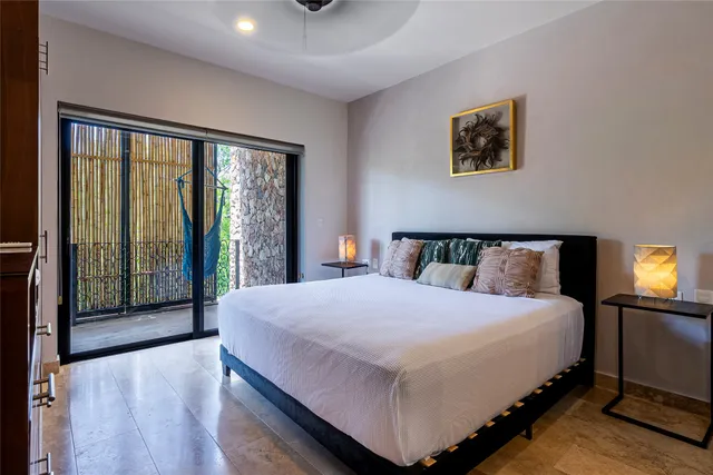 a large bedroom with a bed and wooden floor