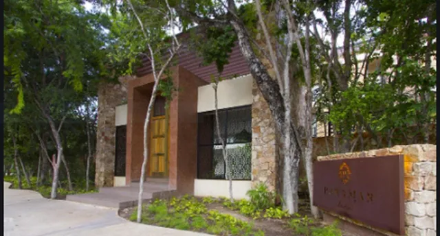 a front view of a house with a tree