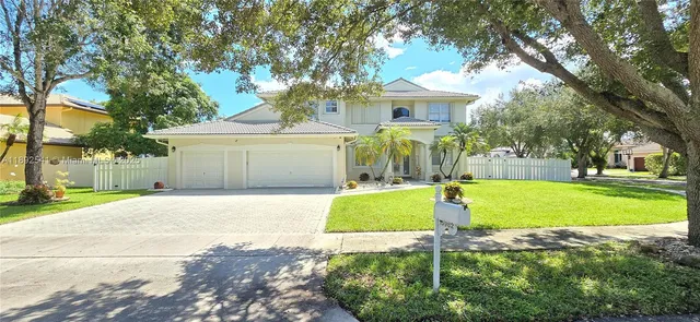 a front view of a house with a yard and trees