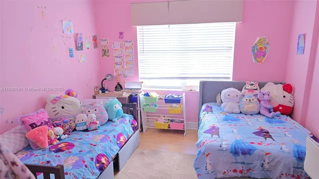 a bedroom with a bed and a flat tv screen on the dresser