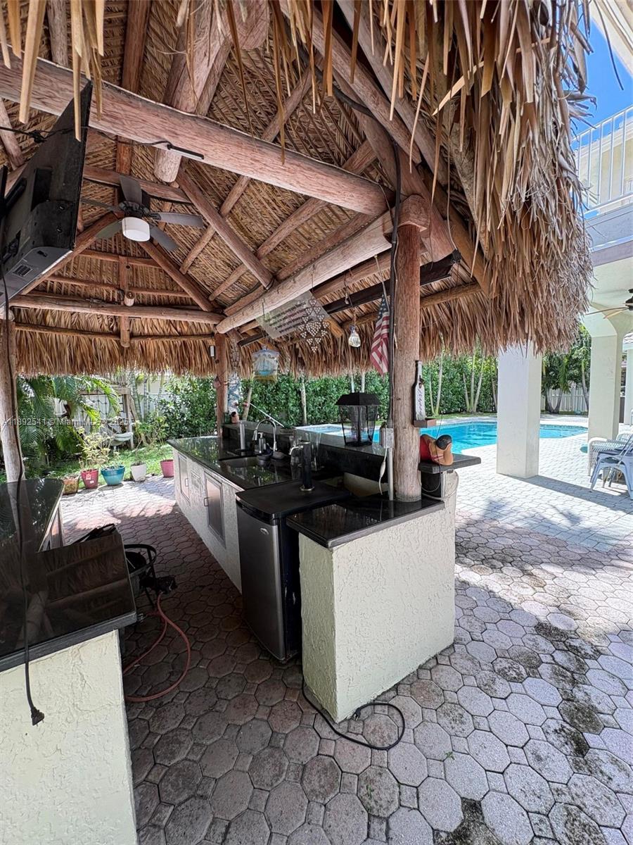 15982 Southwest 61st Street Davie, FL 33331 - Photo 23 of 28 a view of a patio with table and chairs under an umbrella with a small yard