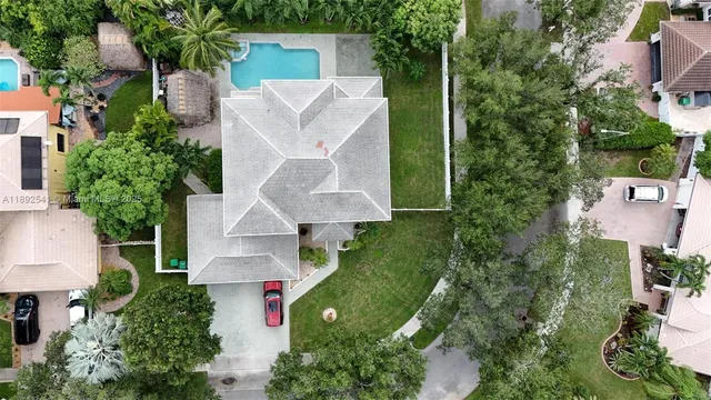 an aerial view of a house with a yard and trees