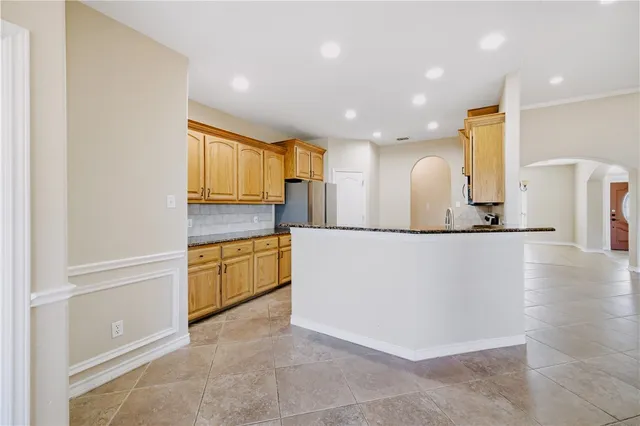 a kitchen with stainless steel appliances granite countertop a stove top oven a sink dishwasher a refrigerator and a microwave