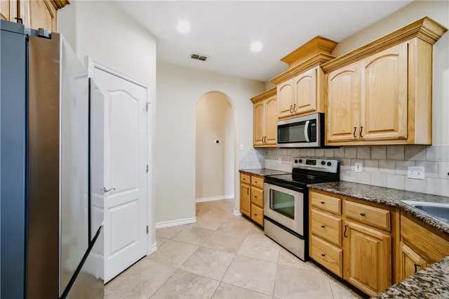 a view of an empty room with a fireplace and a window