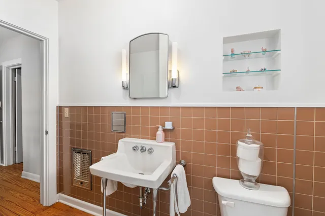 a bathroom with a toilet a sink and mirror