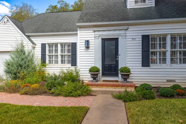 a front view of a house with a garden and seating space