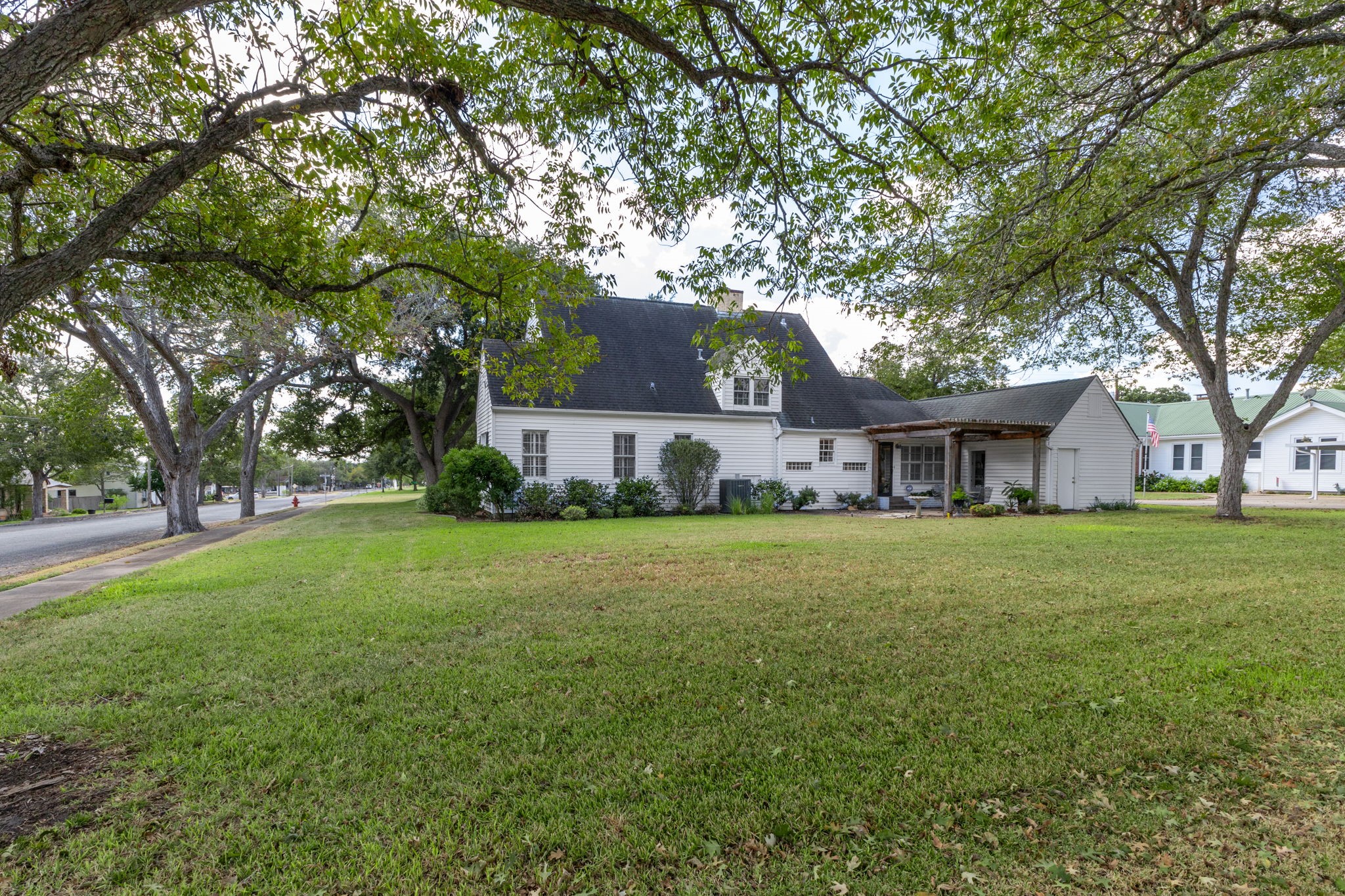 901 Anderson Street Schulenburg, TX 78956 - Photo 33 of 36 a view of a house next to a big yard with large trees