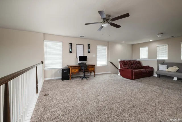 a living room with furniture and a ceiling fan
