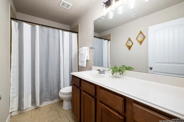 a bathroom with a sink a toilet and a large mirror