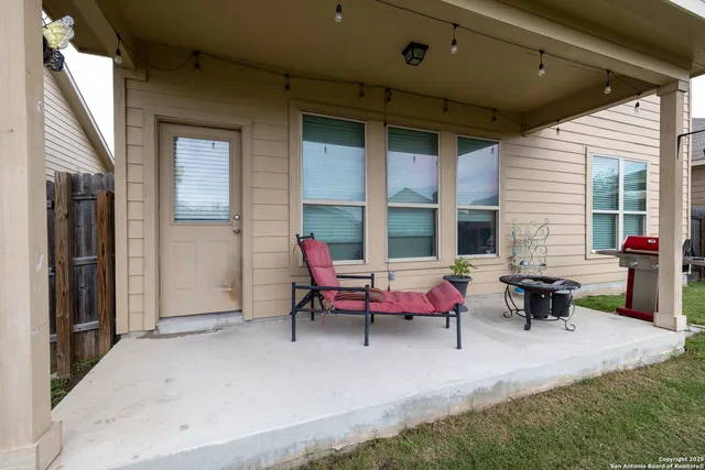 a view of a chair and table in backyard of the house
