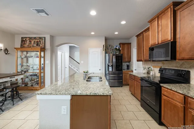 a kitchen with stainless steel appliances granite countertop a sink stove and refrigerator