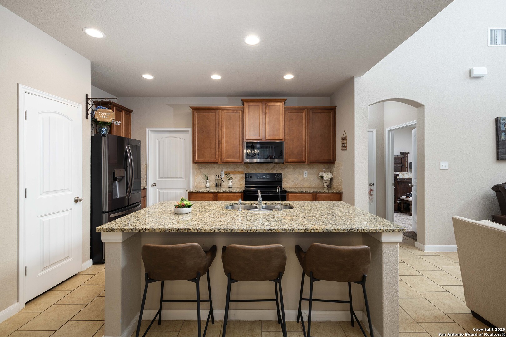 10238 Midsummer Meadow Converse, TX 78109 - Photo 10 of 35 a kitchen with stainless steel appliances granite countertop a table chairs sink refrigerator and cabinets