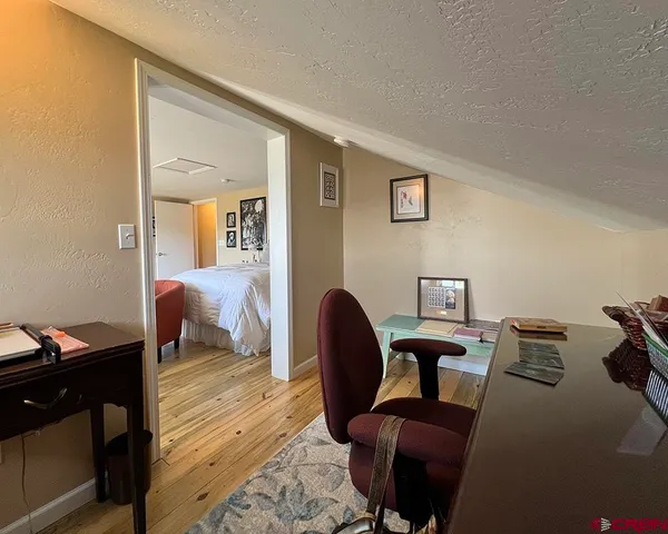 a view of a workspace with furniture and a window