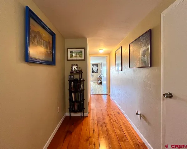 a view of a hallway with wooden floor and closet