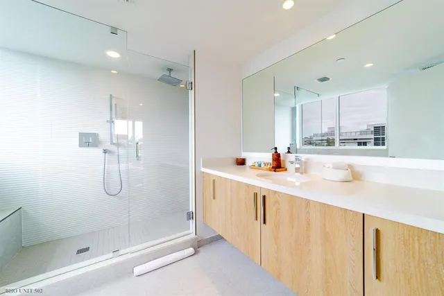 a bathroom with a shower sink and mirror