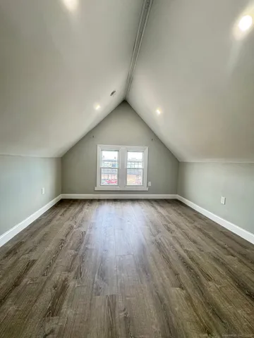 an empty room with wooden floor and entrance