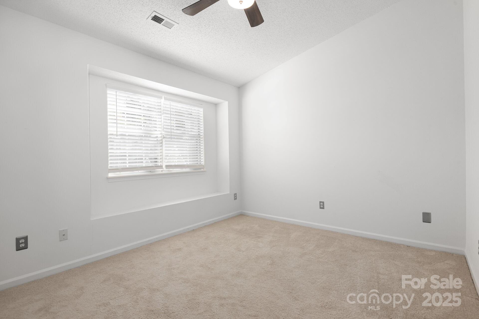 9204 4 Mile Creek Road Charlotte, NC 28277 - Photo 13 of 18 an empty room with ceiling fan and windows