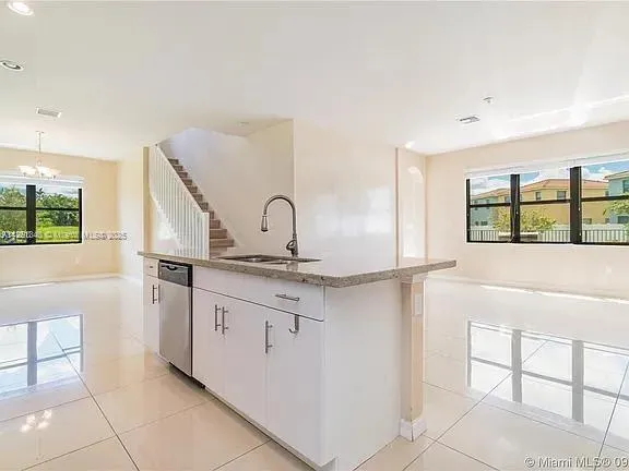 a kitchen with stainless steel appliances granite countertop a sink and a refrigerator