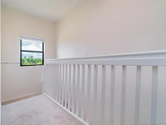 a view of a hallway with wooden floor and a window