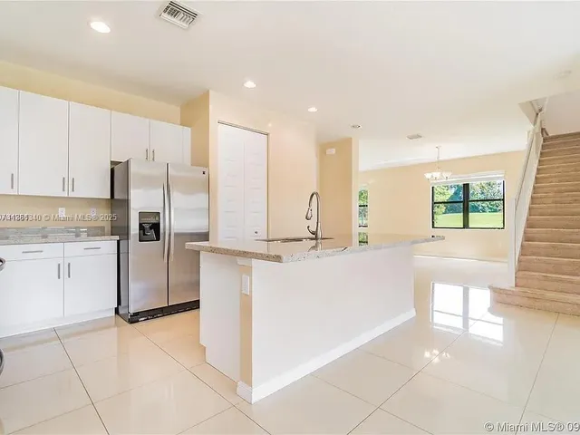 a kitchen with stainless steel appliances a refrigerator sink and cabinets