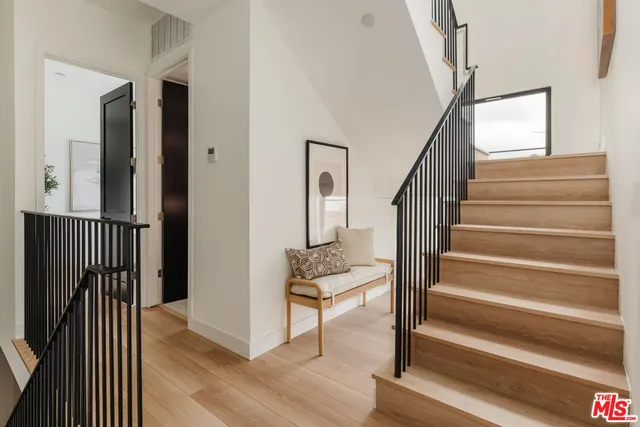 a view of entryway and hall with wooden floor