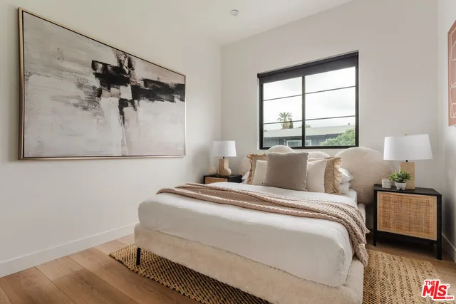 a bedroom with a bed and a painting on the wall