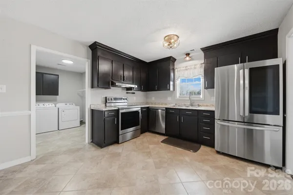 a kitchen with stainless steel appliances kitchen island granite countertop a refrigerator sink and cabinets