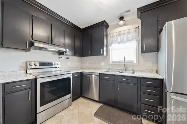 a kitchen with stainless steel appliances granite countertop a sink stove and refrigerator
