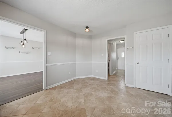 an empty room with closet and a chandelier fan