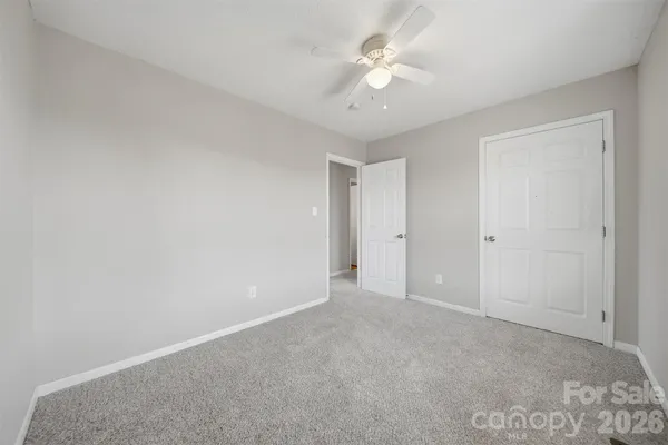 a view of an empty room with a ceiling fan