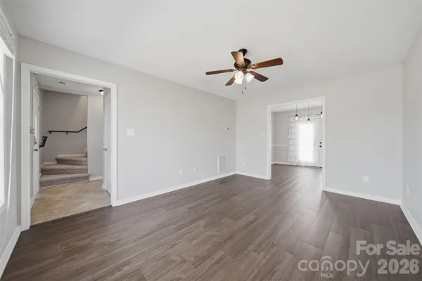 a view of a room with wooden floor and ceiling fan